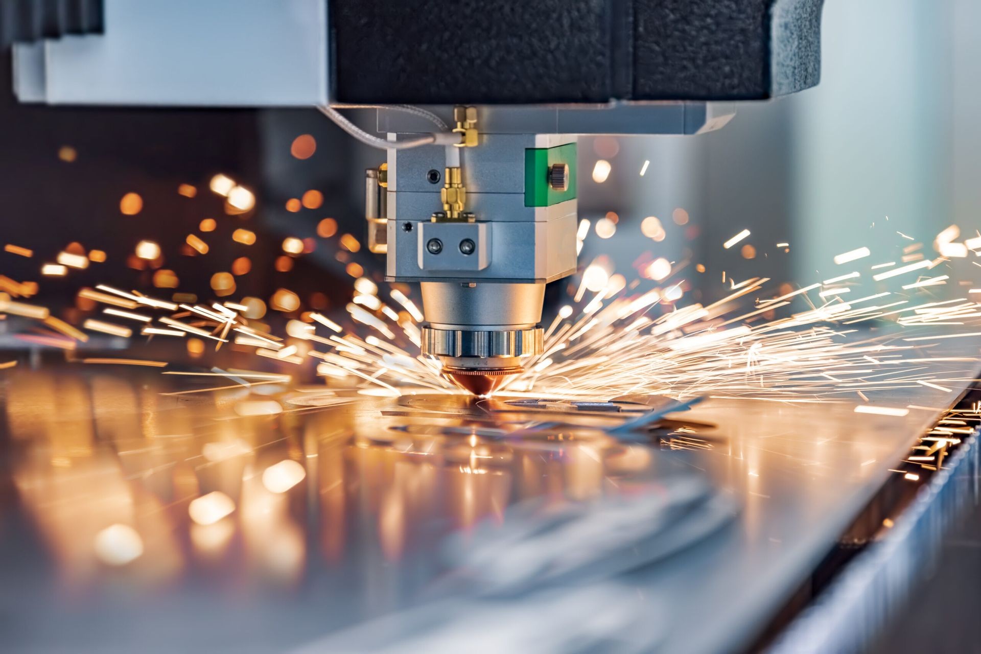 Close-up of a laser cutting machine creating sparks while working on a metal sheet.