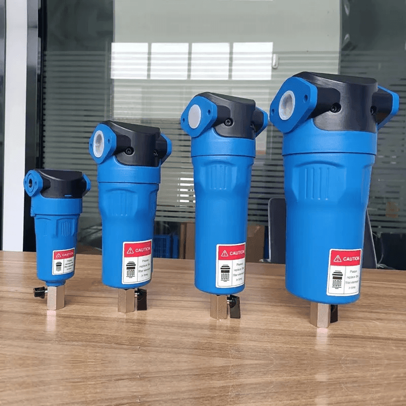 Four blue industrial filters of varying sizes on a wooden table.