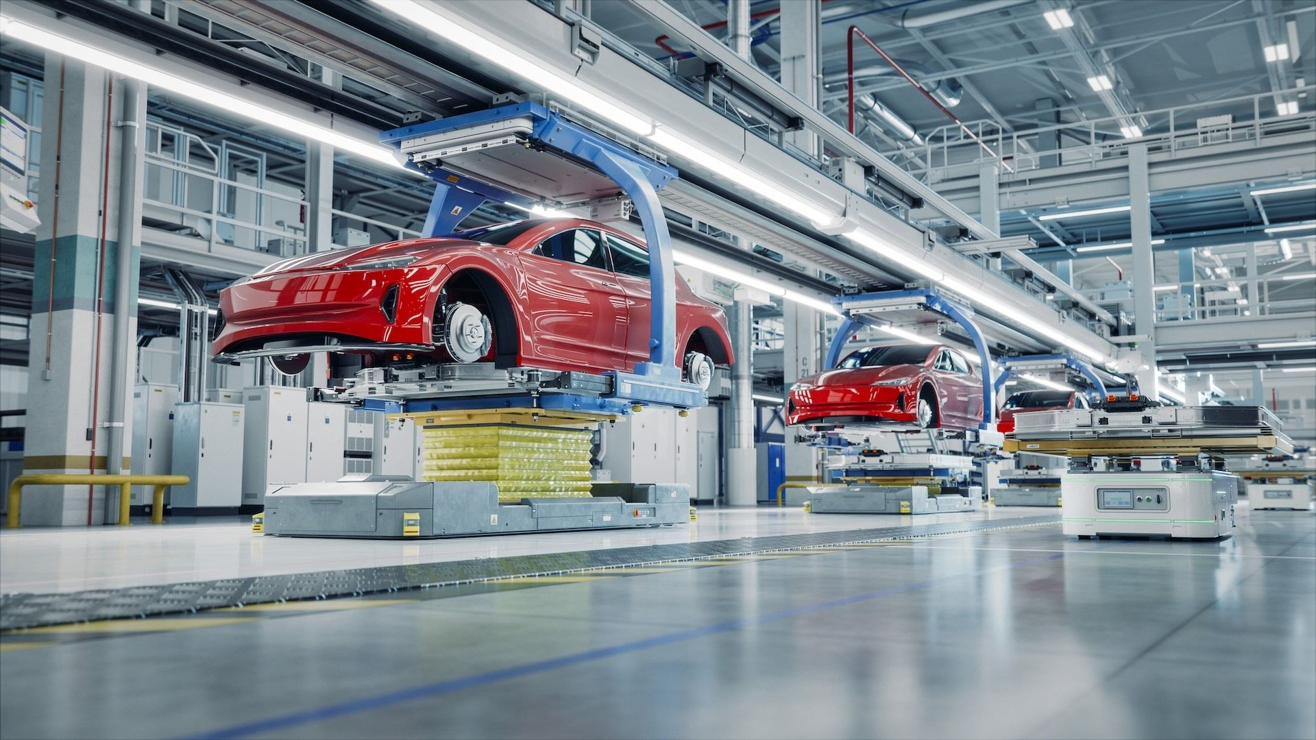 Automated assembly line in a modern car manufacturing plant with red vehicles in various stages of production.